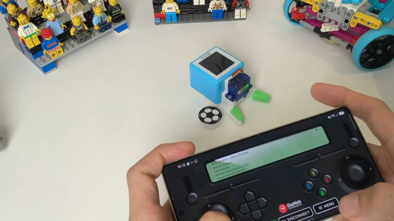 CoCube soccer robot next to a phone running BlueMote